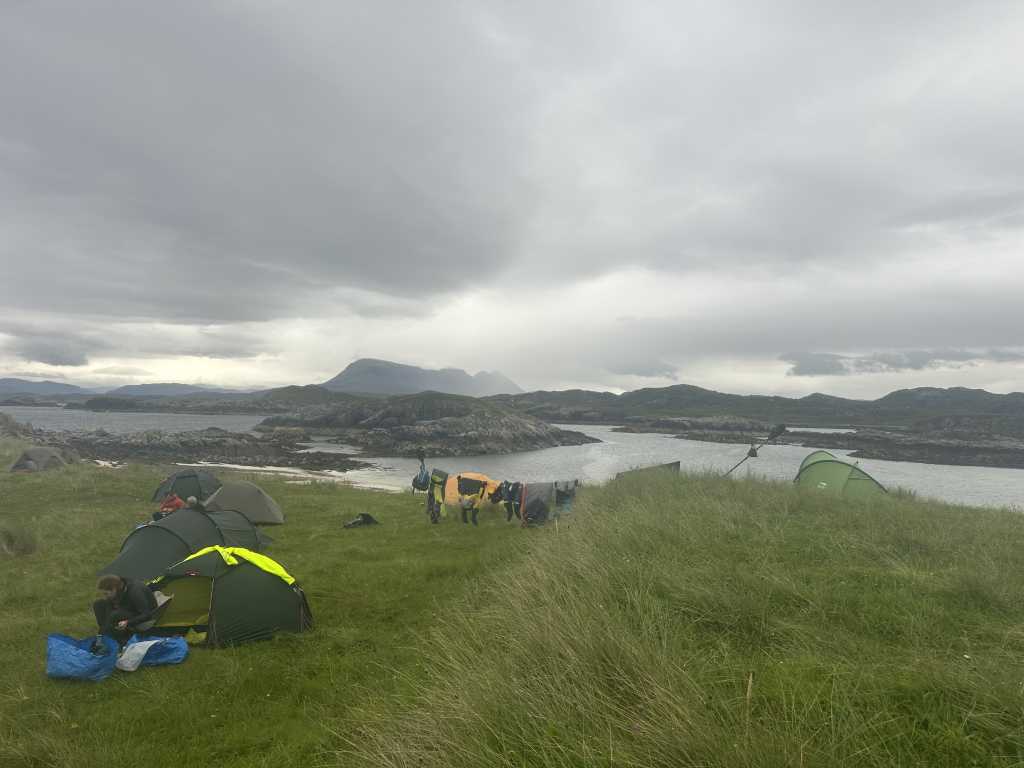 Camp above the tombolo beach at Oldany Island, kit hung out to dry under a grey sky